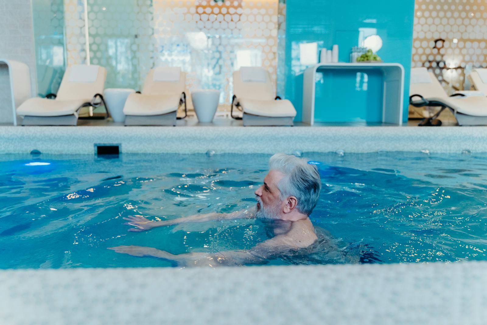 An older adult exercising in a warm indoor therapy pool